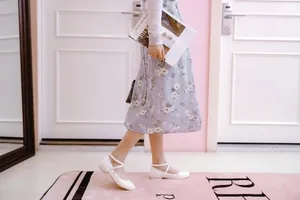 Elegant white Mary Jane flats with cross straps, styled with a floral midi dress
