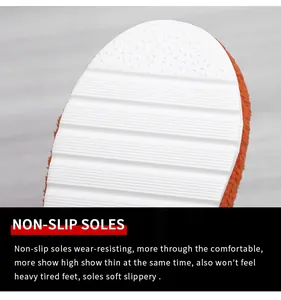 Detailed view of the white non-slip textured sole on stylish orange plush towel slippers