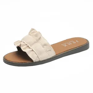 Detailed view of women's flat summer sandals with beige ruffle strap design