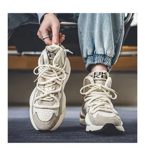 Detailed view of beige chunky dad sneakers with thick braided laces and suede panels
