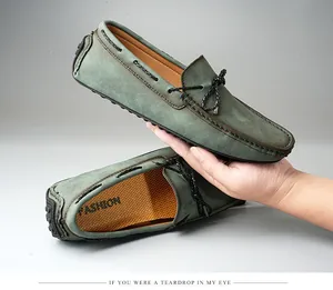 Gros plan détaillé des mocassins en daim vert sauge pour hommes avec coutures à la main.