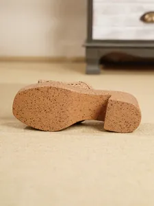 Vista detallada de la suela de cuña con textura de corcho moteado en sandalia