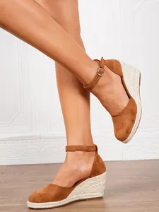 Detail view of brown suede espadrille wedge sandals with adjustable ankle straps