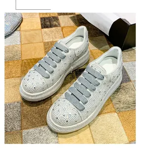 Close-up of women's sparkling rhinestone platform sneakers with grey elastic laces