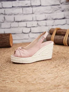 Vista lateral de sandalias de cuña en gamuza rosa con plataforma de esparto de cáñamo.