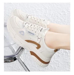 Gedetailleerd zijaanzicht van stijlvolle beige en bruine dames platform dad sneakers aan de voet