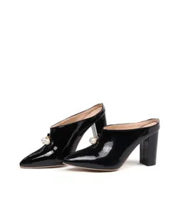 Elegant black patent leather pointed-toe mules with pearl charms and chunky heels.