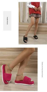 Close-up detail of stylish women's fuzzy platform slippers in pink and black colors