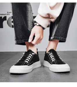 Close-up of men's black canvas sneakers with thick white soles on a model
