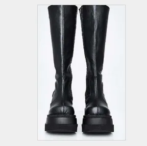 Black Gothic knee-high platform boots featuring thick soles and chunky round toe