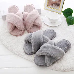 Plush and cozy faux fur crossover slippers in pink and grey for indoor home comfort.