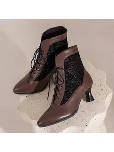Detail of vintage Victorian lace-up boots with brown PU and black lace patterns.