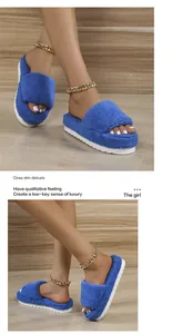 Close-up of blue fuzzy towel slippers with thick white platform sole worn by a model