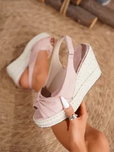 Detalle de sandalias de cuña en ante rosa con plataforma gruesa de cuerda trenzada
