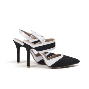 Detalle de elegantes zapatos de tacón destalonados en denim negro y charol blanco