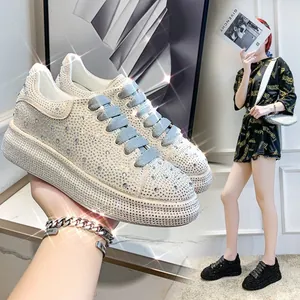 Detail view of sparkling rhinestone-covered platform sneakers with thick white soles