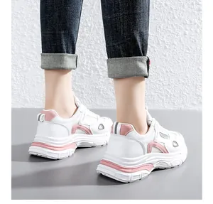 Gedetailleerde weergave van modieuze sneakers met dikke zool voor dames in wit en roze.
