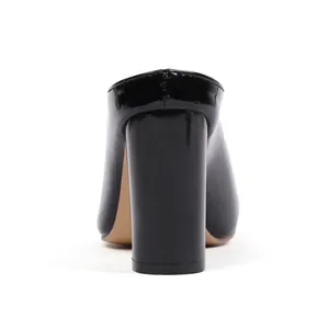 Rear view of black patent leather chunky high-heeled mules with glossy finish.