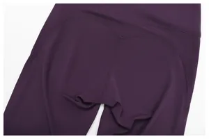 Close-up of high-waisted purple sports leggings with butt-lifting seam details.