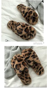 Close-up of fuzzy leopard print cross strap slippers displayed on a cozy knitted blanket