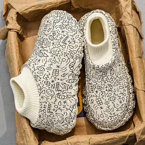 Detailed view of fleece-lined winter slippers with knit collar and doodle pattern