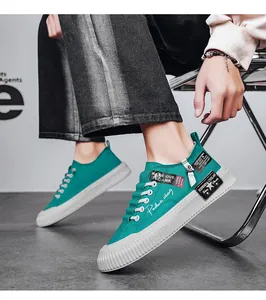 Detail view of men's green canvas sneakers with platform soles and decorative zippers