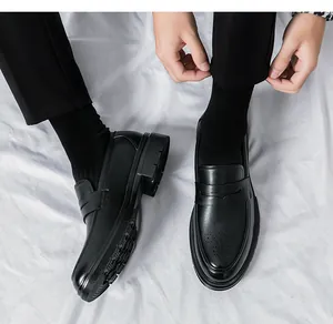 Nahaufnahme der schwarzen Herren-Loafer mit Brogue-Muster und dicker Profilsohle oben.