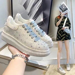 Close-up of sparkling rhinestone platform sneakers featuring elegant light blue laces