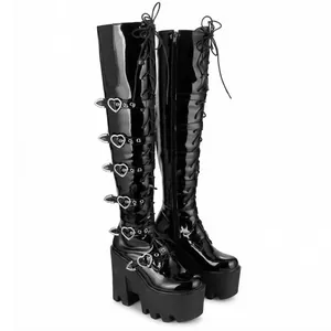 Vue détaillée des bottes gothiques à plateforme en vernis noir avec boucles en cœur