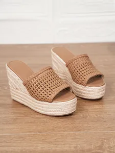 Elegantes sandalias de cuña trenzadas marrones con plataforma alta de paja tejida.