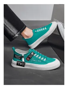 Detail view of teal canvas sneakers with a chunky white platform sole and lace-up design.