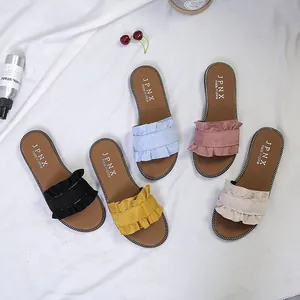 Detailed view of various colored women's flat sandals featuring stylish suede ruffle trim.