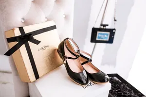 Elegant black patent leather Mary Jane shoes with strap detail and pearl charm.