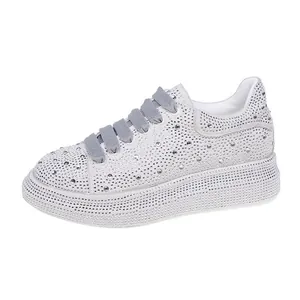 Close-up view of shimmering white rhinestone platform sneakers with grey laces for women
