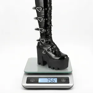 Botte gothique noire à plateforme et boucles en cœur pesant 756 grammes sur balance digitale.