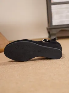 Nahaufnahme der rutschfesten Gummisohle bei schwarzen Sandalen mit Keilabsatz