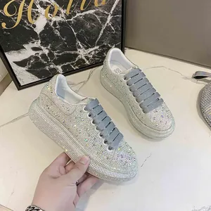 Close-up of sparkling rhinestone-covered platform sneakers with thick grey laces.