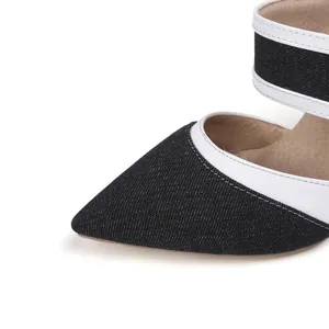 Detalle de zapatos de tacón de mezclilla con punta fina y ribetes de cuero blanco
