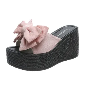Seitenansicht rosa Plateau-Keilsandalen mit dekorativer Schleife und gewebter Sohle