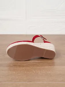 Vista detallada de sandalias de cuña rojas con plataforma de paja y suela marrón