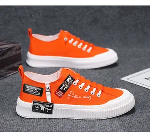 Side view of stylish men's bright orange canvas sneakers with thick white platform soles