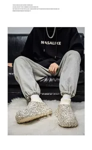 Close-up of graffiti print thick-soled fleece slippers with knit sock collar on white rug.