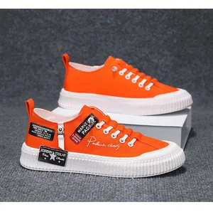 Detailed side view of orange men's thick-sole canvas sneakers with decorative patches