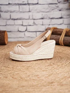 Vista detallada de las sandalias de cuña beige con plataforma de yute trenzado y tira