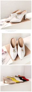 Details of elegant white pointy toe mules with pearl charms and multi-color options