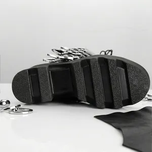 Gros plan sur la semelle plateforme antidérapante des bottes punk noires à anneaux métal