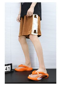 Seitenansicht der orangefarbenen EVA-Flip-Flops mit dicken Sohlen und Smile-Dekor.