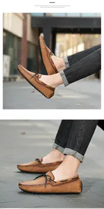 Vue détaillée de mocassins en cuir marron portés avec un jean noir sur pavés.