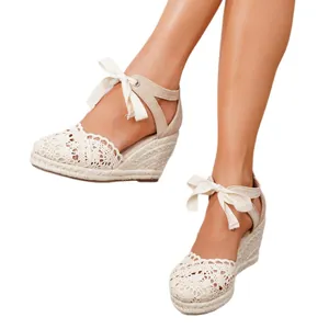 Alpargatas de cuña con cordones y encaje beige para mujer con suela de esparto natural.
