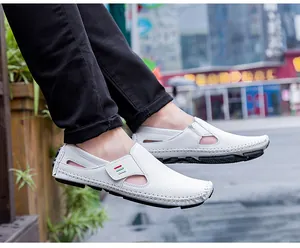 Close-up detail view of white men's breathable hollow-out loafers worn outdoors